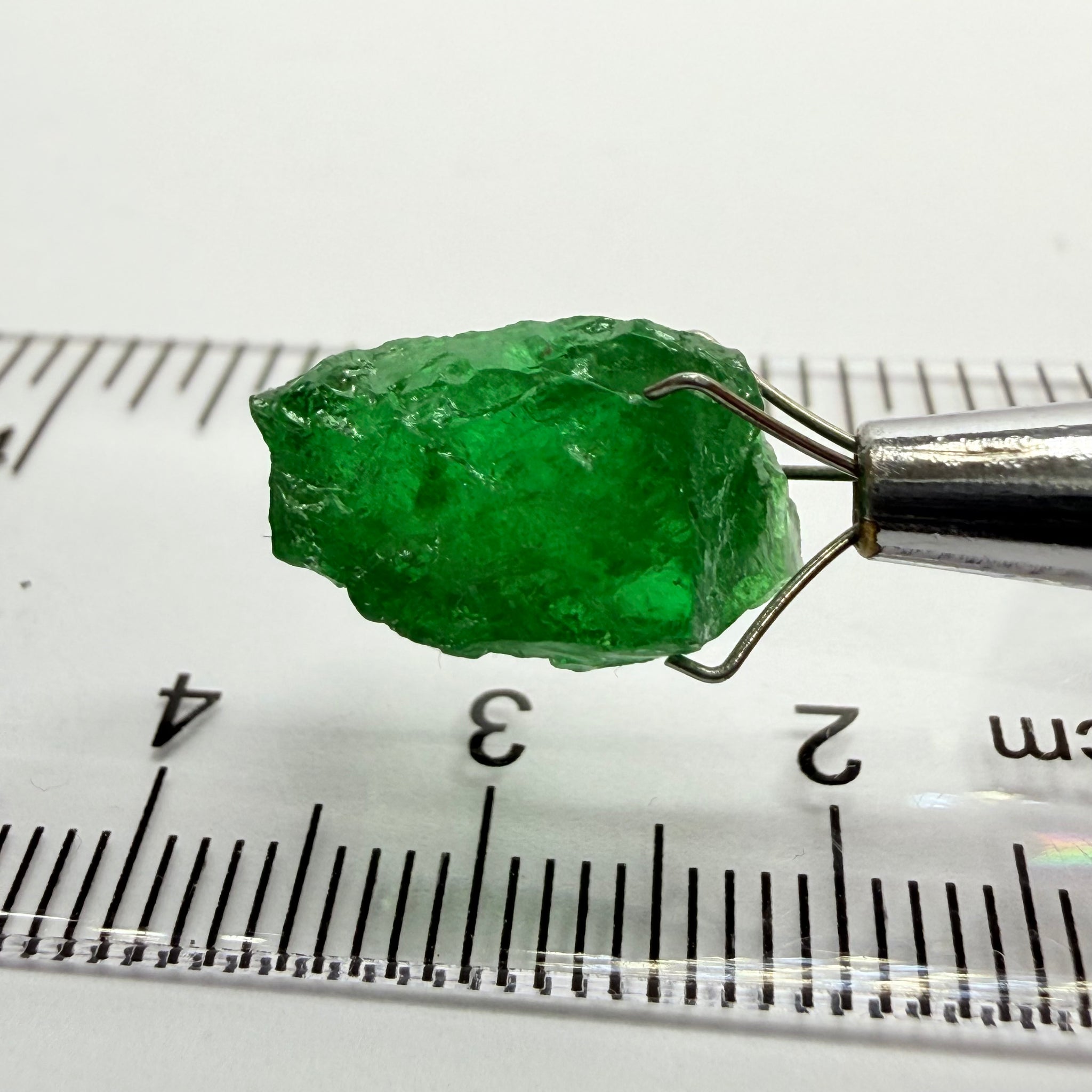 Tsavorite Garnet, 8.64ct, Tanzania, Untreated Unheated. Has a crack at one end, you can see the light reflecting on the left side, see circled pic. Rest has spots and veils, but well saturated colour