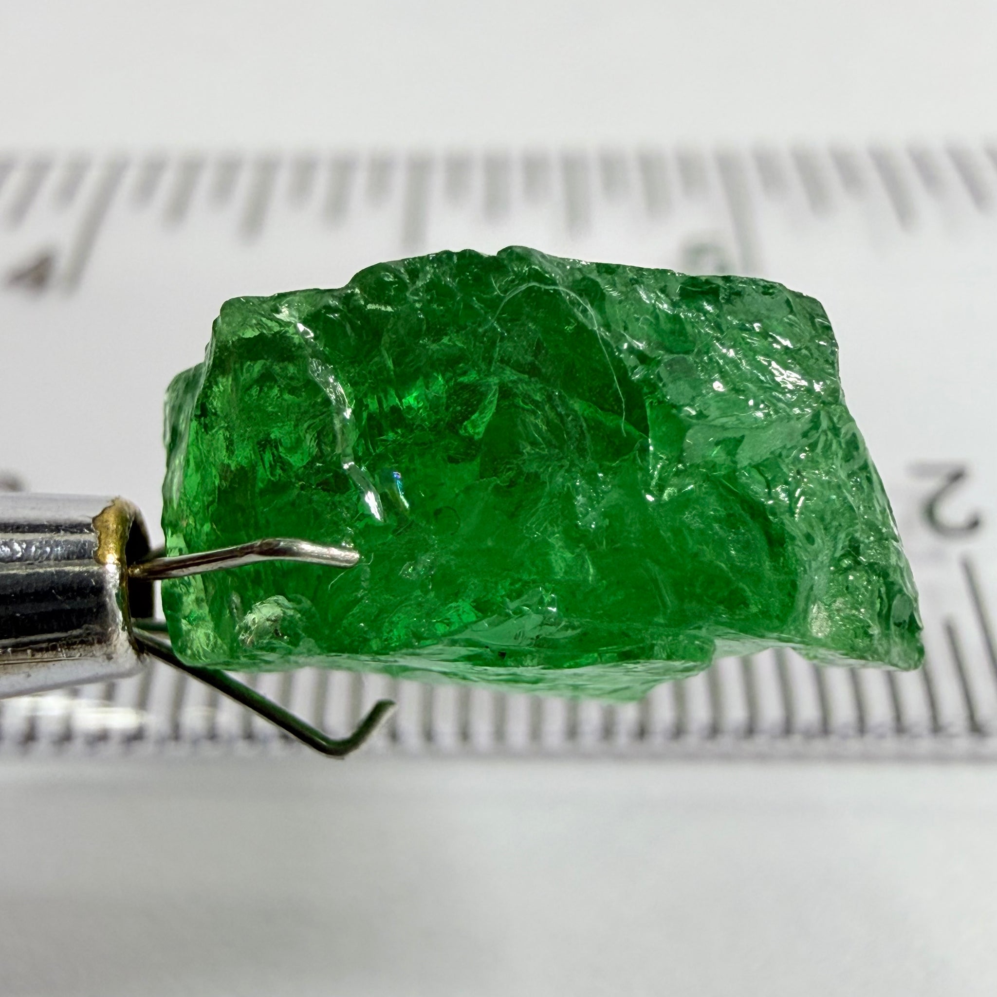 Tsavorite Garnet, 8.64ct, Tanzania, Untreated Unheated. Has a crack at one end, you can see the light reflecting on the left side, see circled pic. Rest has spots and veils, but well saturated colour