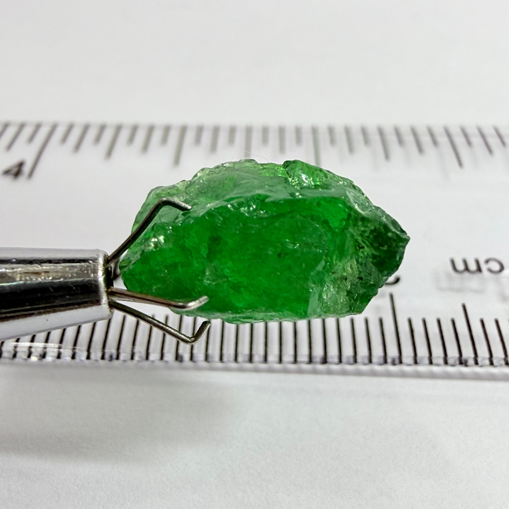 Tsavorite Garnet, 8.64ct, Tanzania, Untreated Unheated. Has a crack at one end, you can see the light reflecting on the left side, see circled pic. Rest has spots and veils, but well saturated colour