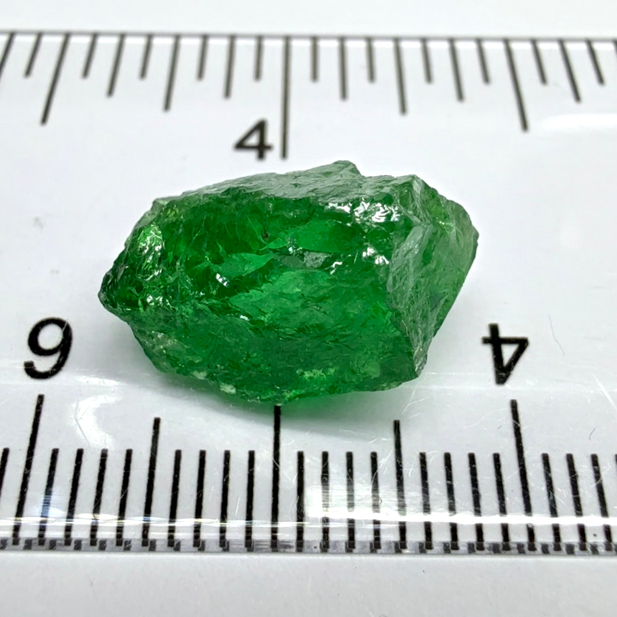 Tsavorite Garnet, 8.64ct, Tanzania, Untreated Unheated. Has a crack at one end, you can see the light reflecting on the left side, see circled pic. Rest has spots and veils, but well saturated colour