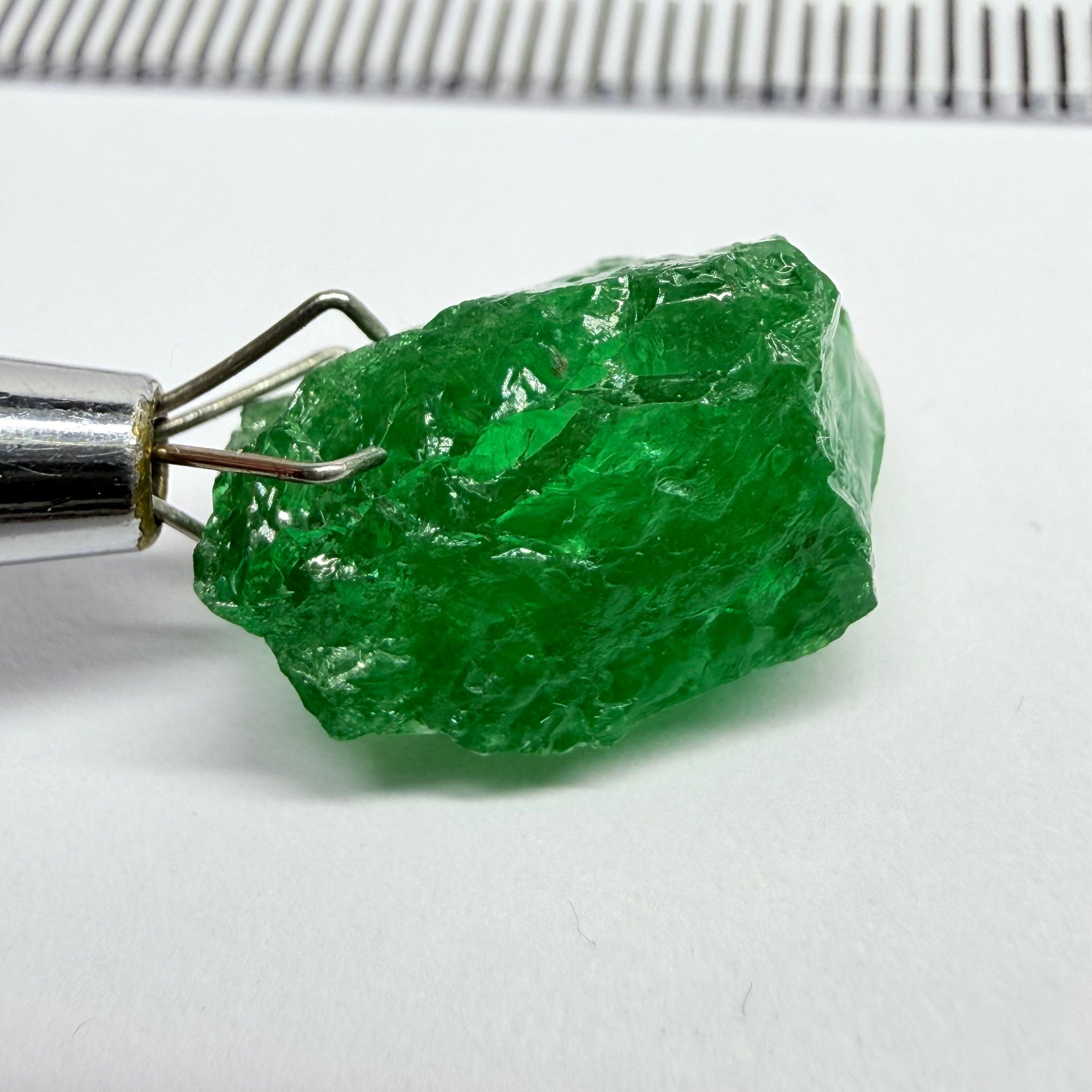 Tsavorite Garnet, 8.64ct, Tanzania, Untreated Unheated. Has a crack at one end, you can see the light reflecting on the left side, see circled pic. Rest has spots and veils, but well saturated colour