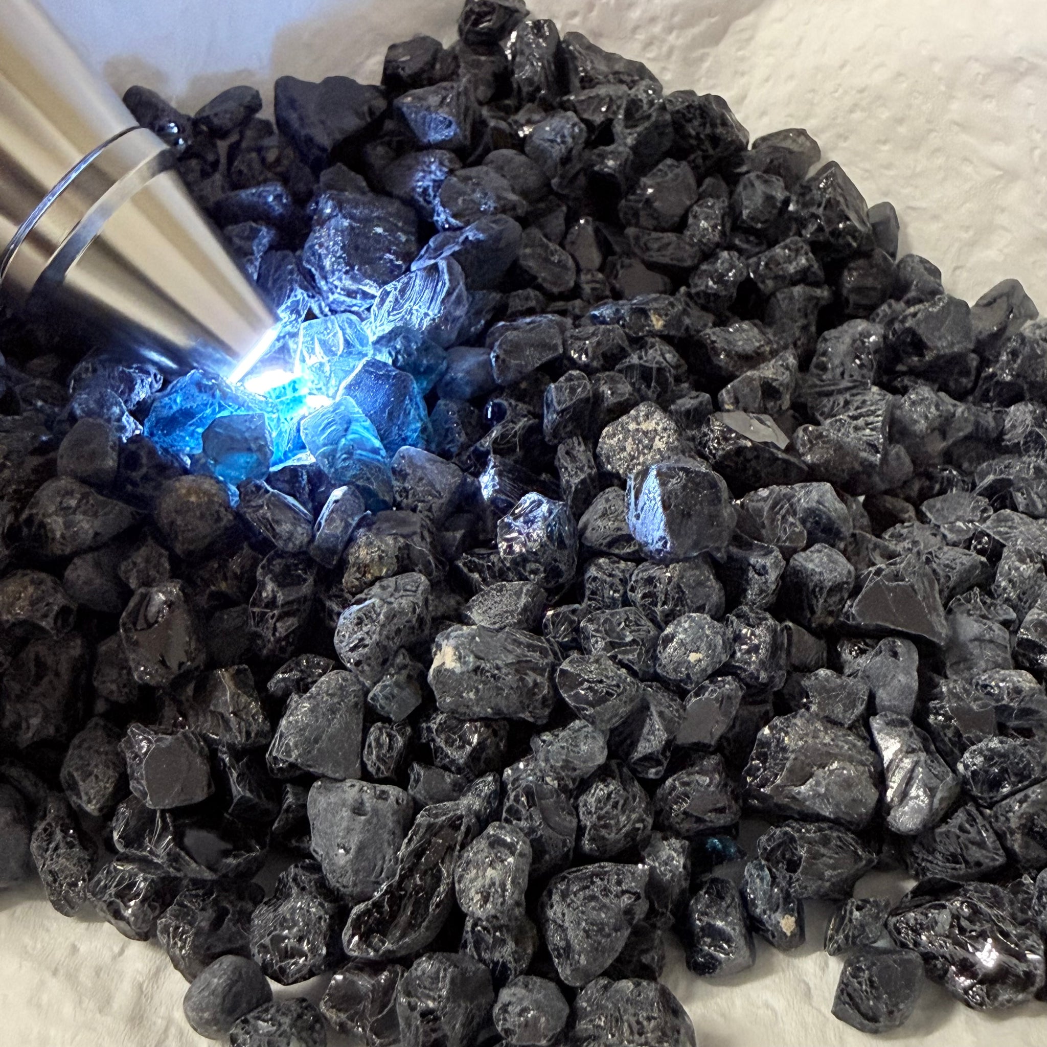 Midnight Blue Spinel Lot, 309.70gm / 1548.50ct, Mozambique, Untreated Unheated. All transparent stones, midnight blue but dark in normal light. See both videos. Almost all are vvs. Not sure if heat will lighten it. 3ct-11ct