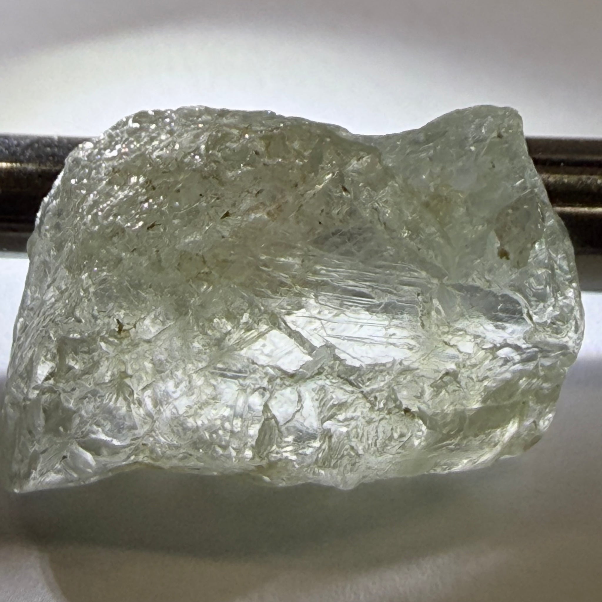 Umba Sapphire, 21.93ct, Umba, Tanzania, Untreated Unheated, flattish shape, moderate to heavy inclusions on the outside with a transparent needled, slightly included center, see the backlit photos
